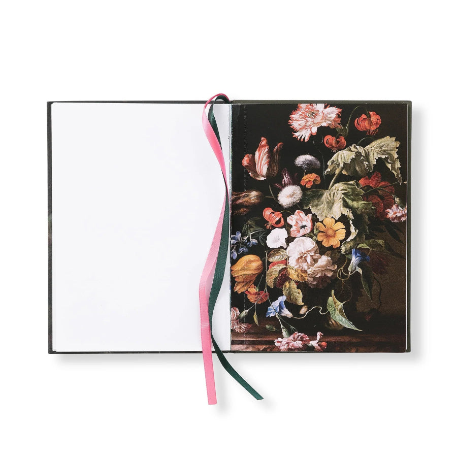 A hardcover notebook or journal with a classic still life floral painting on the cover, featuring a blank white page on the left and two ribbon bookmarks in pink and dark green.