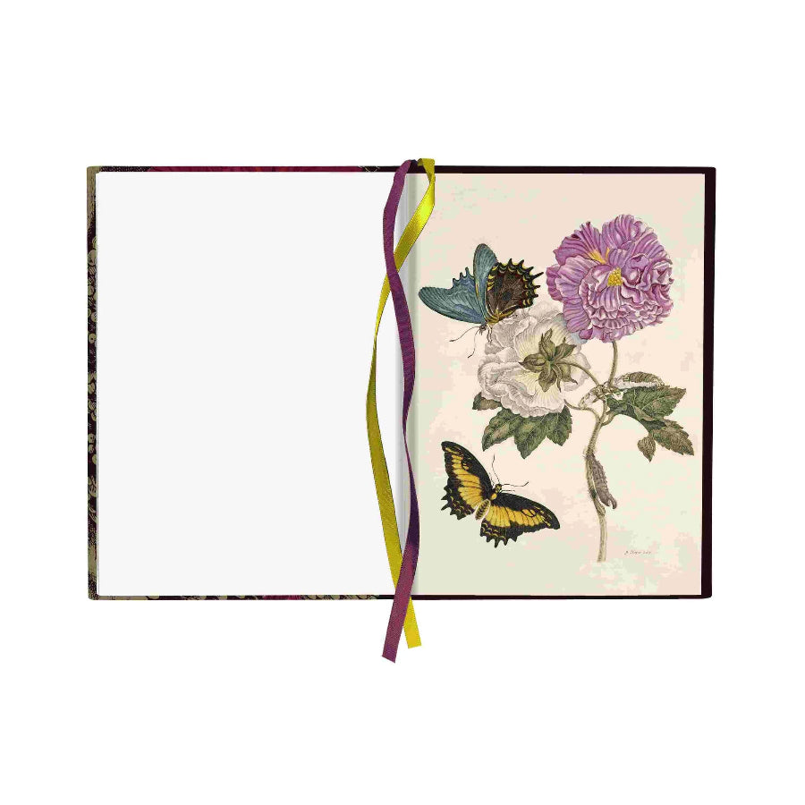 An open notebook or journal with a blank white left page and a right page featuring a vintage-style botanical illustration of a purple flower, white rose, and two butterflies. A ribbon bookmark in yellow and purple hangs from the center against a plain white background.