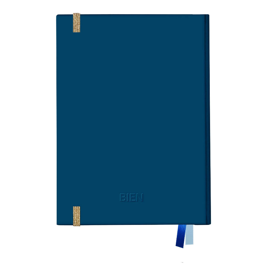 A dark blue hardcover notebook with gold ribbon bookmarks and a matching blue and white ribbon bookmark, shown on a plain white background.