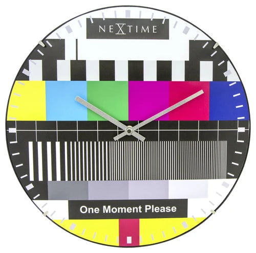 NeXtime wall clock with colorful test pattern and 'One Moment Please' text