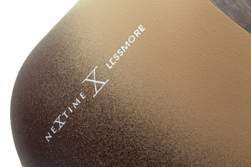 Close-up of a textured tan-to-brown surface with a white printed logo reading NEXTIME X LCSSMORE.