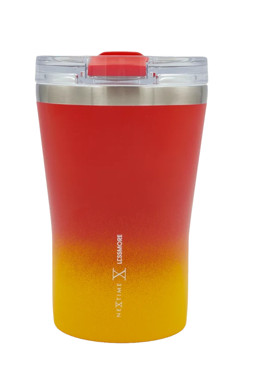 A Next Time Lessmore insulated travel tumbler with a red-to-yellow gradient design, featuring a clear lid with a red flip-top straw cover and a stainless steel rim.