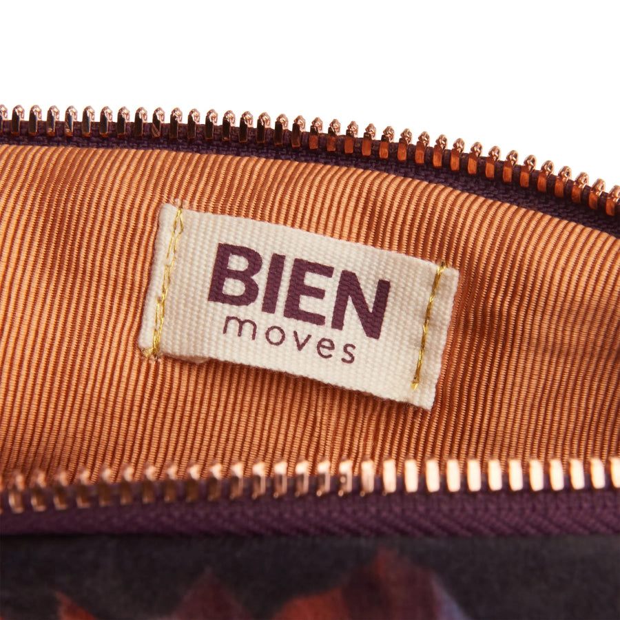 Close-up of a 'BIEN moves' label on a brown fabric surface.