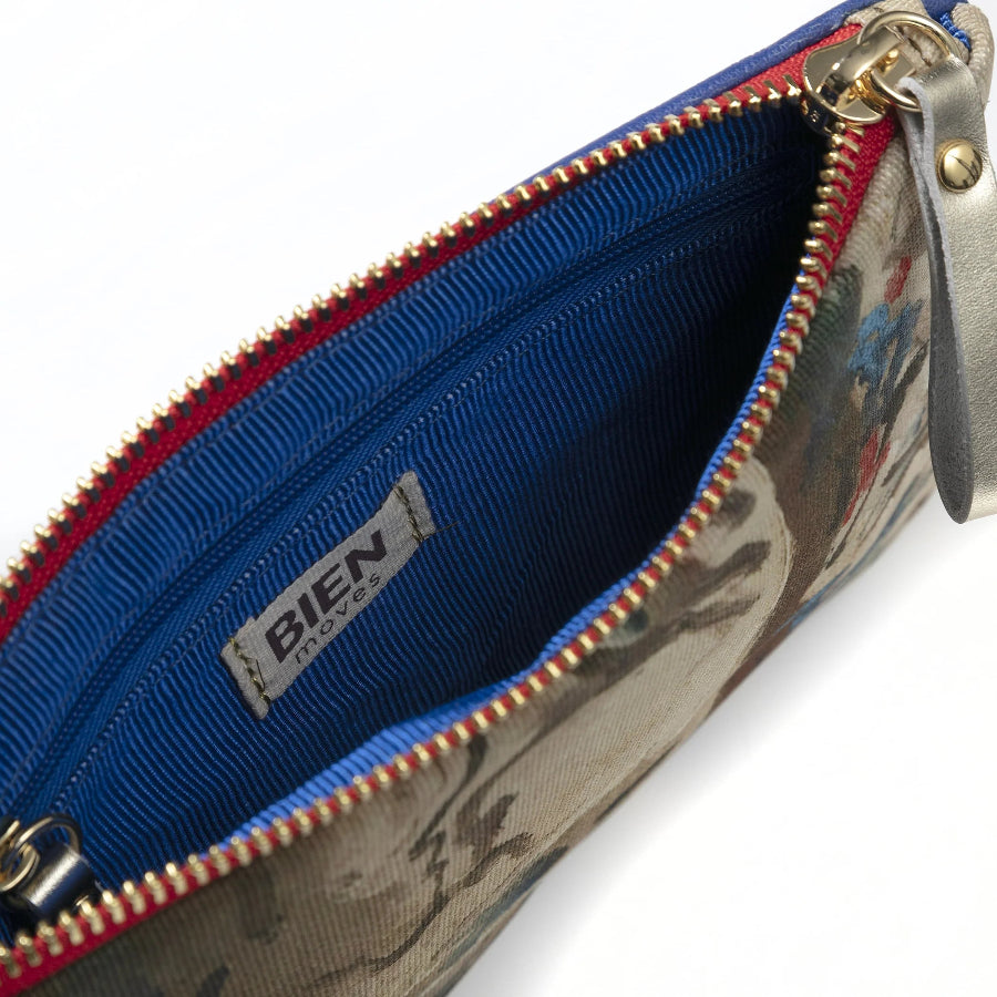 Close-up of a BIEN PARIS clutch or pouch showing the interior with a vibrant blue ribbed lining, a red zipper tape, and a floral patterned exterior.