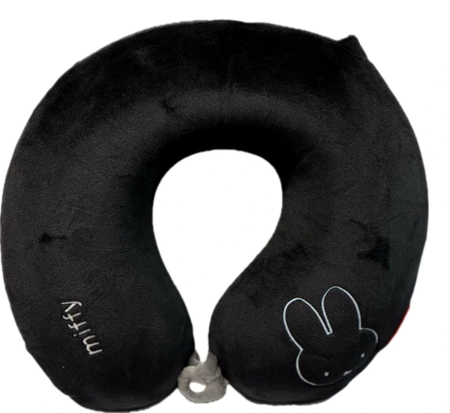 Black travel neck pillow with a cartoon design on a white background