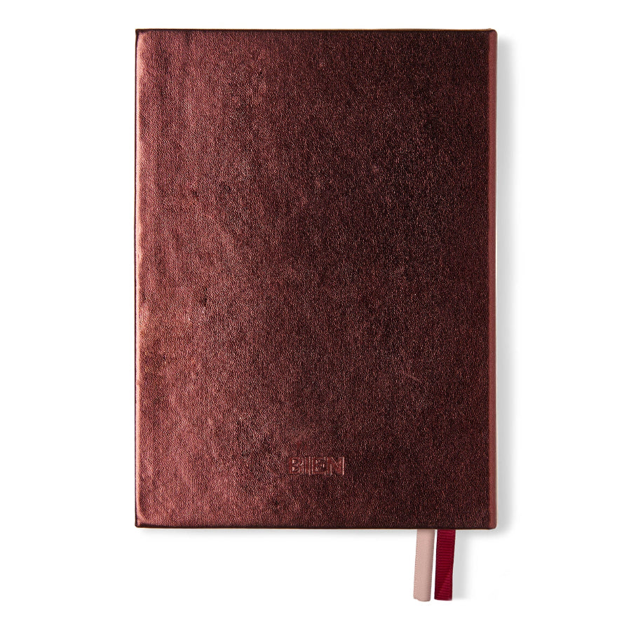 A textured dark red leather journal with a debossed 'BILGAN' logo near the bottom and two ribbon bookmarks, shown on a plain white background.