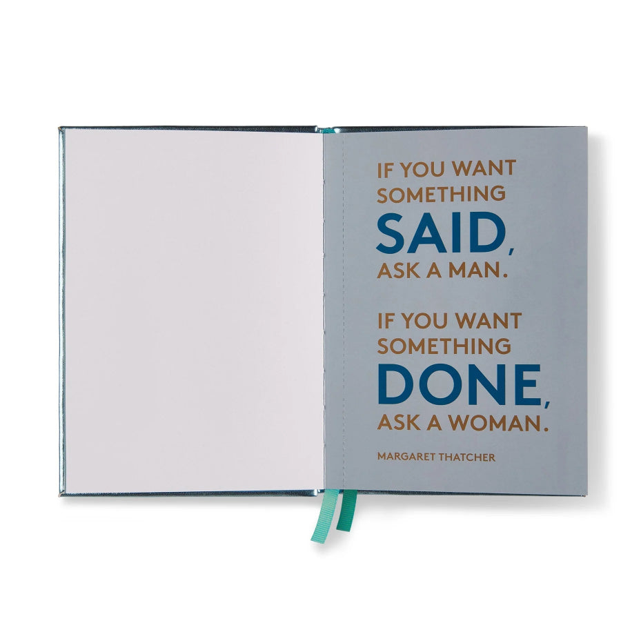 An open notebook or journal with a light gray cover and blank white pages on the left. The right page features a motivational quote by Margaret Thatcher in blue and brown text: 'IF YOU WANT SOMETHING SAID, ASK A MAN.