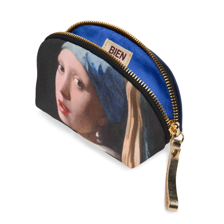 A small zippered pouch with a blue satin interior and a printed artwork of a woman with a blue head covering on the exterior. The pouch has a gold zipper, a gold pull tab, and a small beige label that reads BIEN.