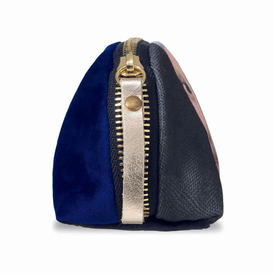 A small zippered pouch with a color-blocked design featuring a deep blue velvet front, a black textured side panel, and a metallic gold zipper with a gold pull tab.