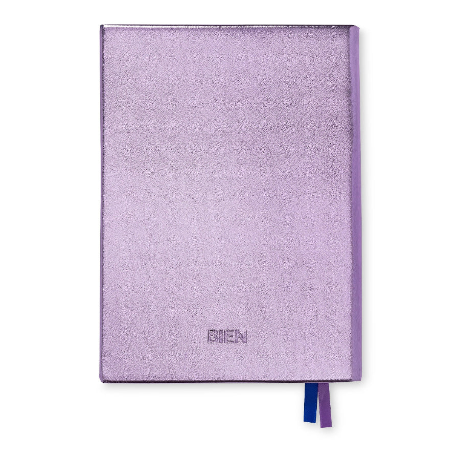 A lavender purple textured notebook with a matching purple spine and ribbon bookmarks in blue and purple, shown on a plain white background.