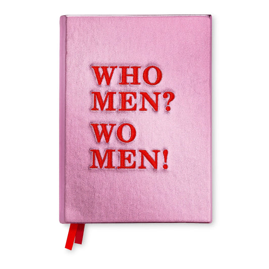 A pink hardcover notebook with red raised text reading 'WHO MEN? WO MEN!' on the cover, with a red ribbon bookmark hanging from the bottom.