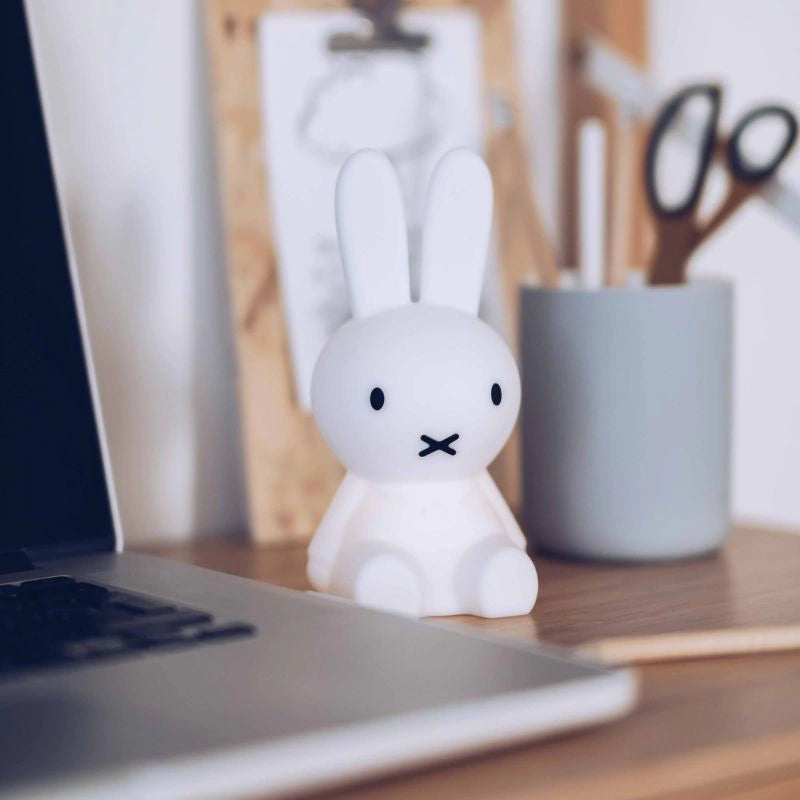 White rabbit-shaped lamp on a desk next to a laptop