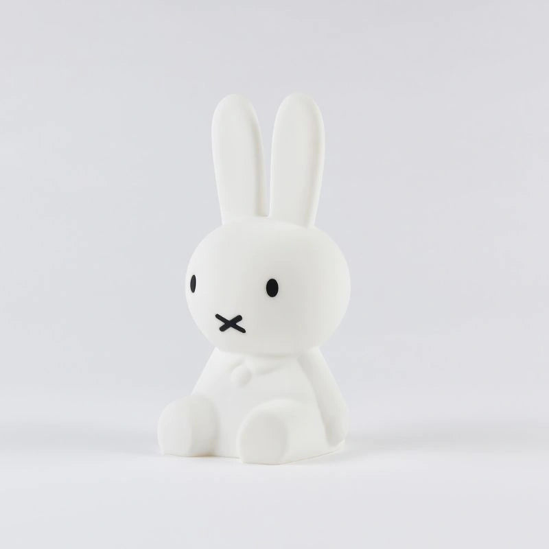 White rabbit figurine with a sad expression on a light gray background